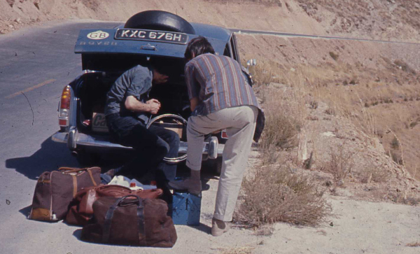 two men with luggage in car boot