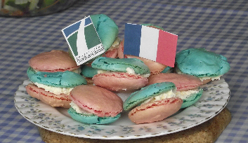 plate of blue and red macarons with white filling