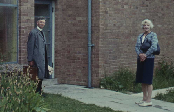 minister and wife at back door of church