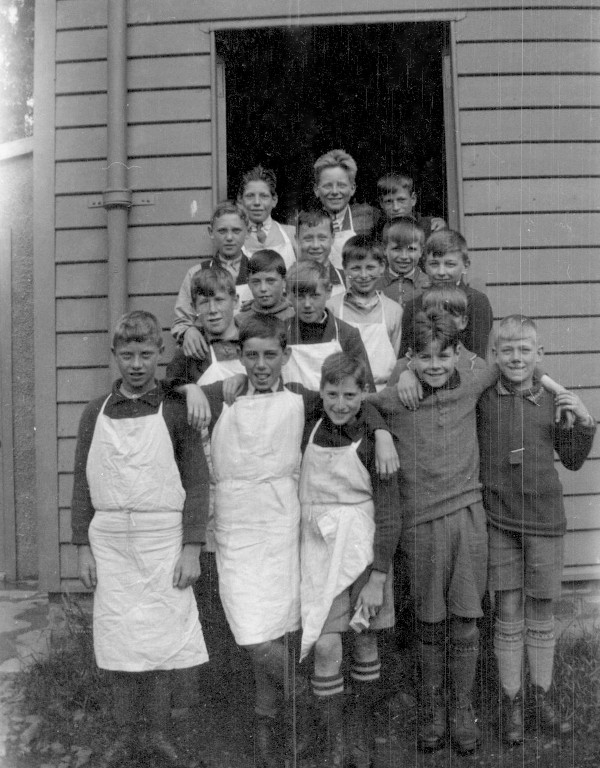 boys standing outside wooden building