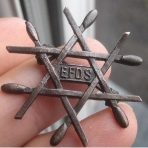 badge made up of a triangle formed by paralleled pairs of dance swords